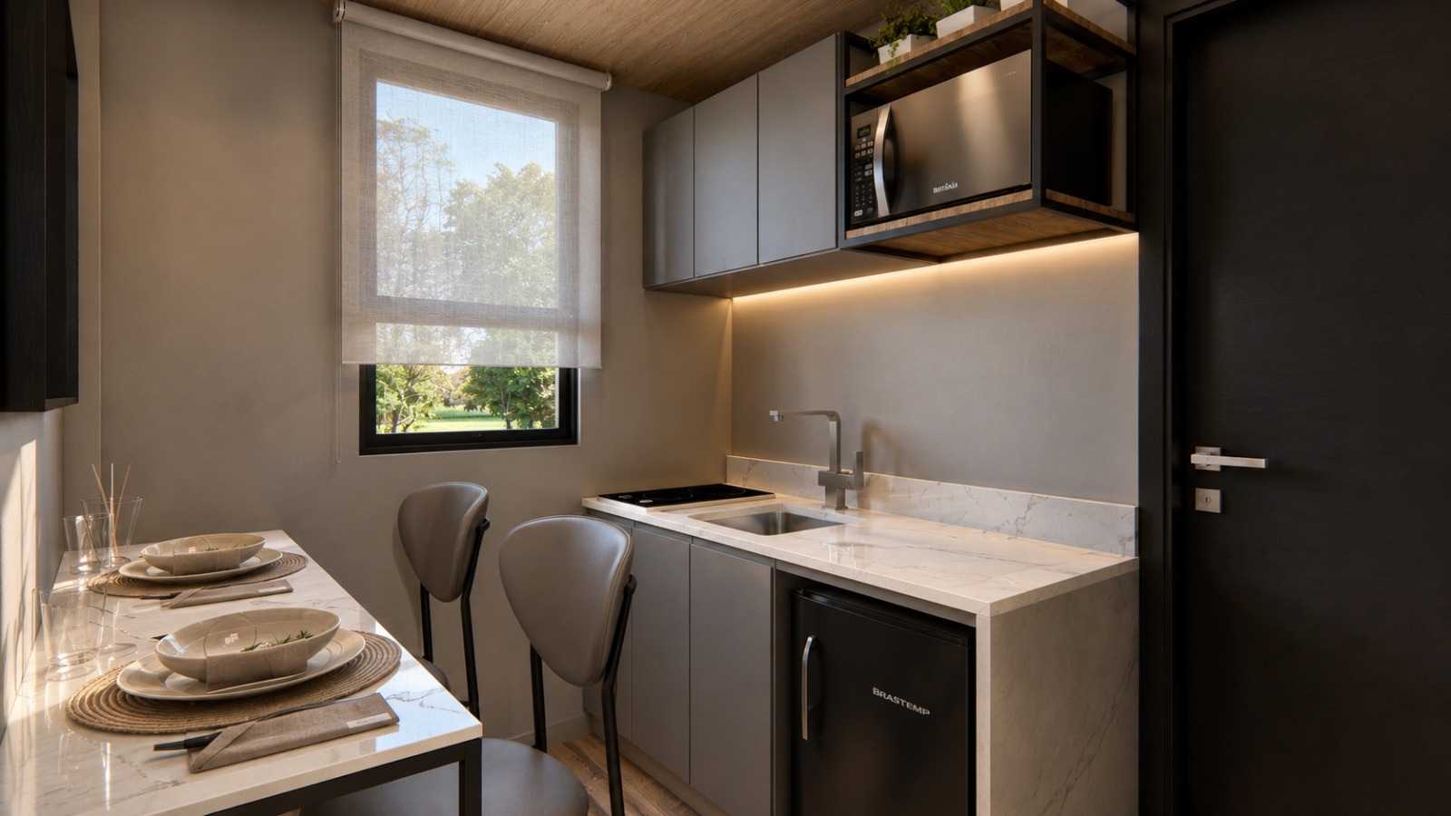 Loft — cozinha compacta com bancada em pedra e mesa de refeições