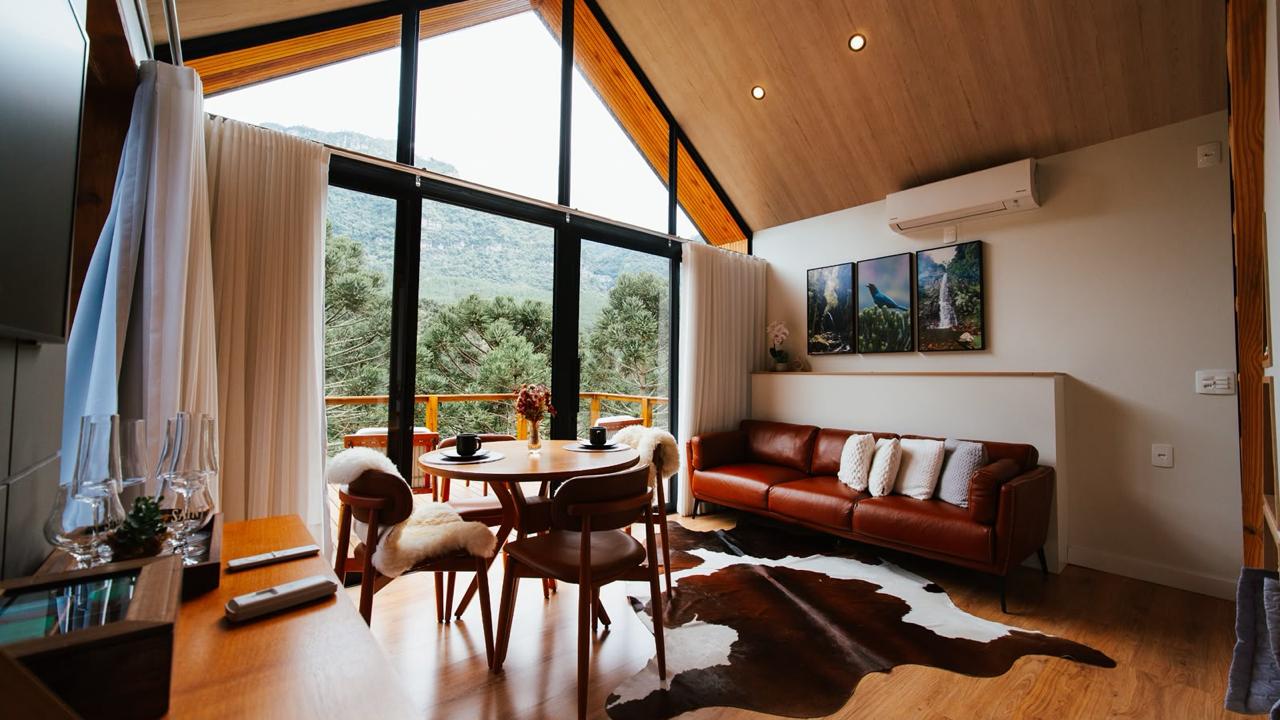 Sala com sofá de couro e fachada envidraçada