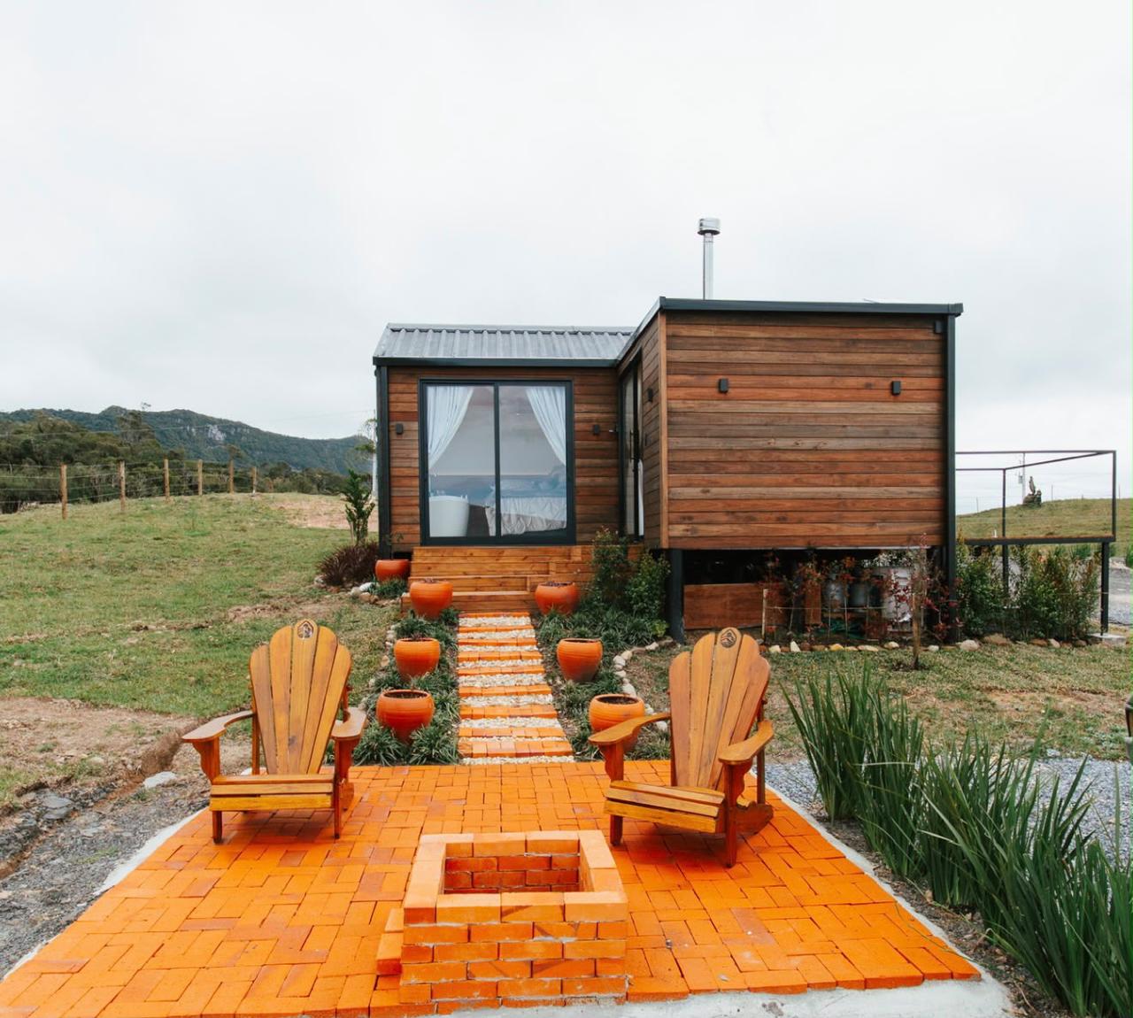 Cabana de madeira com pátio de tijolos e fogueira