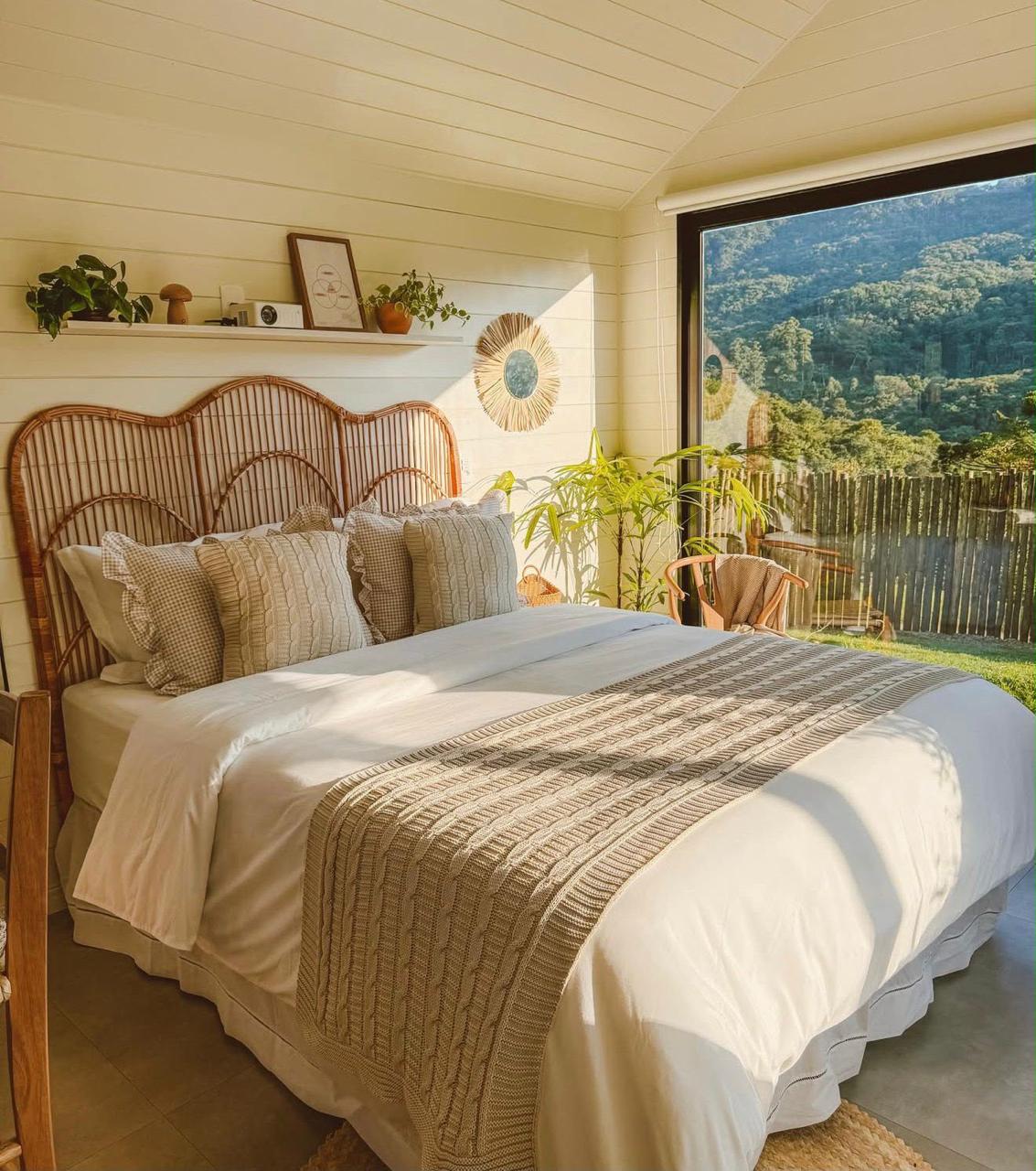 Quarto aconchegante com janela para a mata