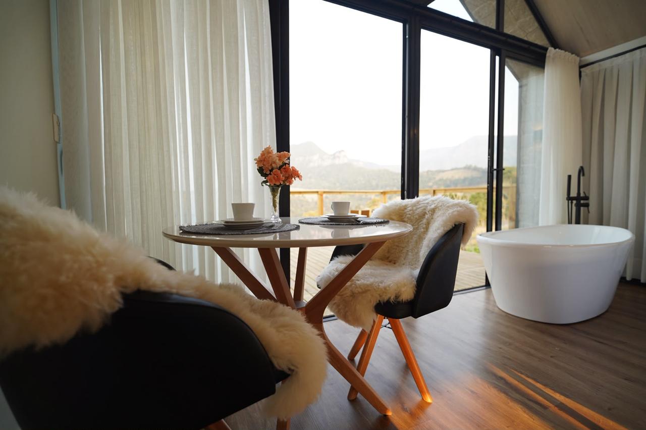 Mesa para dois e banheira com vista para as montanhas